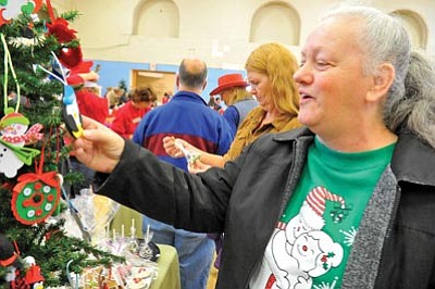 Matt Hinshaw/The Daily Courier<br>Bridget West checks out a homemade Christmas ornament at the Boy Scouts of America Troop 7617 booth during the 2011 Stocking-Stuffer Bazaar in Prescott. The event takes place again on Saturday.