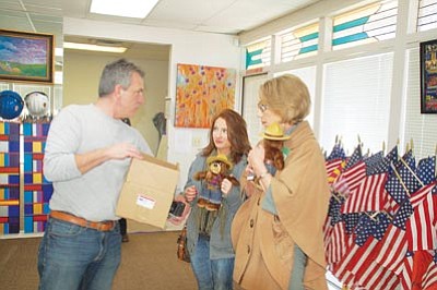 Cindy Barks/The Daily Courier<br>Volunteer Ered Matthew shows donors Jonnie Olsness, center, and Reva McGillivrae the stuffed Smokey Bear toys to be given as gifts of appreciation to Jan Monroe and Dottie Morris, the volunteer directors  of the tribute fence preservation project.
