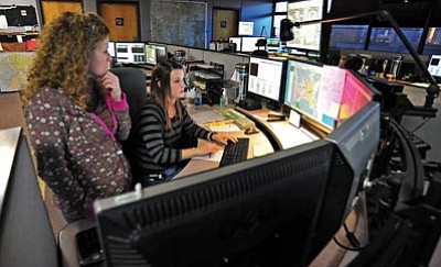 Matt Hinshaw/The Daily Courier<br>Dispatch training officer Jeanine Burto, left, works with Megan Neighbors, a communication specialist trainee, on answering 911 calls Thursday afternoon at the Prescott Regional Communication Center.

