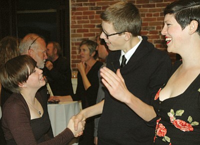 Patrick Whitehurst/The Daily Courier<br>
Ashley Brown, president of the Launch Pad teen center’s teen board, greets fellow teen board member Olin Morman and Launch Pad volunteer Zoe Cavas during Saturday’s fundraiser above ‘Tis Gallery in downtown Prescott. The Valentine-themed event raised more than $11,000, according to organizers.