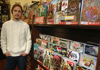 Patrick Whitehurst/The Daily Courier<br>
Comic book specialist Seth Luck stands next to shelves filled with new comic books at the Peregrine Book Company near downtown Prescott. Luck oversees the store’s vast collection of new and used titles. He’s recently taken charge of cataloguing more than 30,000 comic books for the local bookstore.