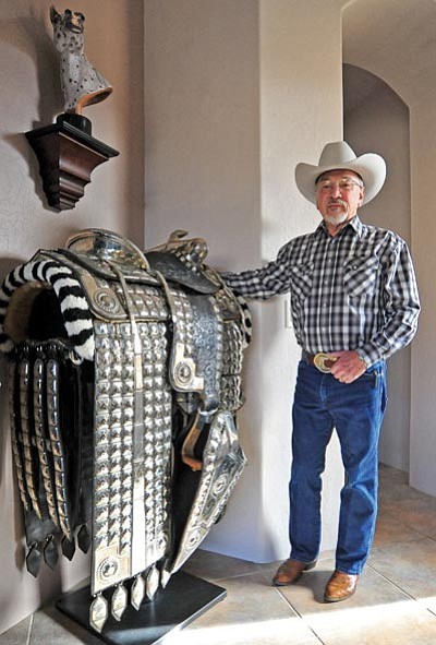 Matt Hinshaw/The Daily Courier<br>Leatherworker Dusty Johnson poses next to a vintage silver horse saddle he restored. “If I don’t do these, they will be gone” for future generations, Johnson said.