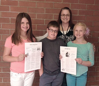 Courtesy photo<br>
Fifth-grade teacher Ms. Kristi Spengler poses with Chloe Carr, left, Seth DePuy and Kaelee Keppel, right, with copies of their student newspaper, “If You Only Knew.”