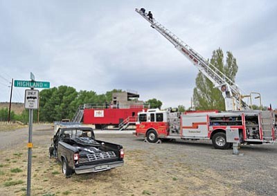 Matt Hinshaw/The Daily Courier<br>Prescott Fire Department firefighters practice climbing up a ladder truck in high-wind conditions Friday morning at the Prescott Fire and Police Department Training Facility.