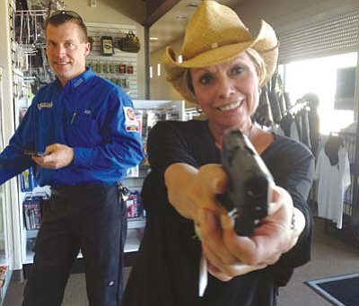 Tom Scanlon/The Daily Courier<br>
Rozanne Charington tries out a new handgun at the Prescott Gun Club.