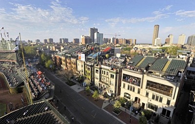 Paul Beaty/The Associated Press<br>In this May 14, 2013 file photo, a view from the upper deck stands at Wrigley Field shows the rooftop bleachers outside the right field wall along Sheffield Avenue across the street. The owners of the Chicago Cubs say they’re moving forward with plans to renovate and expand Wrigley Field, despite the threat of lawsuits by the owners of the adjacent rooftop venues overlooking the 100-year-old ballpark.