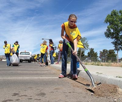 Kaylyn Bushman, 12, clears out the curbs at Mountain Valley Park in Prescott Valley during a service project inspired by a social media campaign to honor the 19 fallen Granite Mountain Hotshots on this anniversary month of the Yarnell Hill Fire tragedy. (Photo by Richard Haddad/WNI)