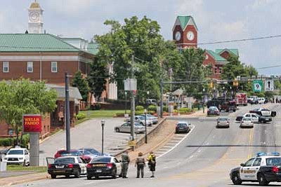 Atlanta Journal-Constitution, John Spink/The Associated Press<br>
Law enforcement canvasses the scene in Cumming, Georgia on Friday after a man shot a deputy at the Forsyth County courthouse, before dying in a shootout, officials said.