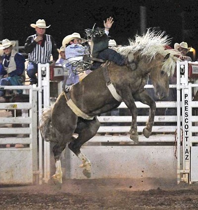 Matt Hinshaw/The Daily Courier<br>Richmond Champion of The Woodlands, Texas, gets a ride from Sun Pop in the Bareback Bronc Riding event Monday night during the first performance of the Prescott Frontier Days’ “World’s Oldest Rodeo” at the Prescott Rodeo Grounds.