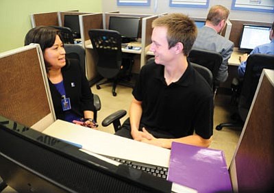 Les Stukenberg/
The Daily Courier<br>Emily Ellis helps an applicant apply for jobs at the grand opening of the Goodwill Career Center on Iron Springs Road in Prescott Thursday.
