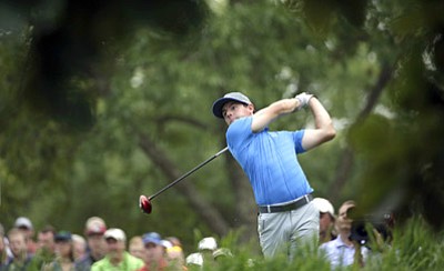David J. Phillip/The Associated Press<br>Rory McIlroy watches his tee shot on the 18th hole during the third round of the PGA Championship Saturday.