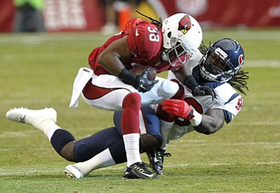 Ross D. Franklin/The Associated Press<br>Cardinals running back Andre Ellington (38) is tackled by Houston linebacker Jadeveon Clowney during Saturday night's first half in Glendale.
