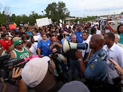 Missouri State Highway Patrol Capt. Ronald Johnson addresses a crowd of protesters, asking them to stay on the sidewalk and not block traffic, Thursday in Ferguson, Mo. (David Carson/The Associated Press)