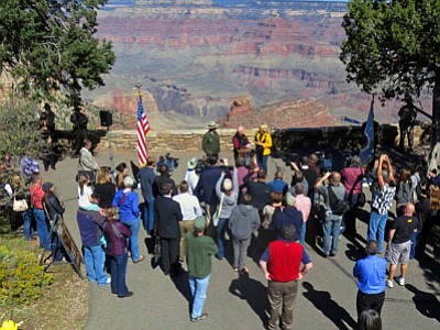 In this Oct. 12, 2013 file photo, Arizona Gov. Jan  Brewer, rear center right, and park officials announce the reopening of Grand Canyon National Park. An effort by the Grand Canyon to make a lucrative contract more attractive to bidders means the park will defer planned spending on new lighting, cave monitoring, building a composting toilet and tracking an endangered fish that recently reappeared in the canyon. (Associated Press, file photo)