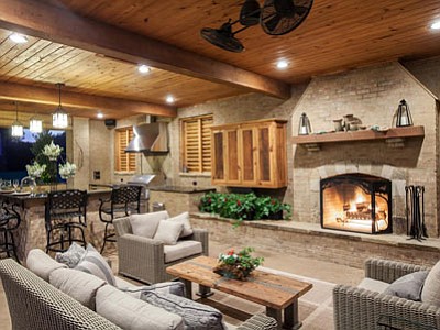 This photo shows an outdoor space that has been built to be useable regardless of the weather. The fireplace, built into the side of the existing house, and blinds that create a barrier against wind in the winter make the partially exposed room comfortable year-round. (Associated Press photo)