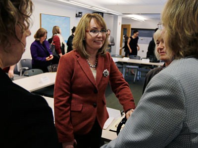 Former Arizona Rep. Gabby Giffords is greeted by supporters following a roundtable discussion on the first stop of her "Protect All Women" tour in Portland, Maine, on Tuesday. Giffords, who was severely wounded in a 2011 shooting that killed six in Tucson, is seeking to elevate the issue of gun violence against women on state and federal levels. (Associated Press photo/Charles Krupa)