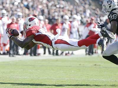 Ben Margot/The Associated Press<br>
Arizona Cardinals wide receiver Jaron Brown catches a pass in front of Oakland Raiders cornerback T.J. Carrie during their game in Oakland on Sunday.