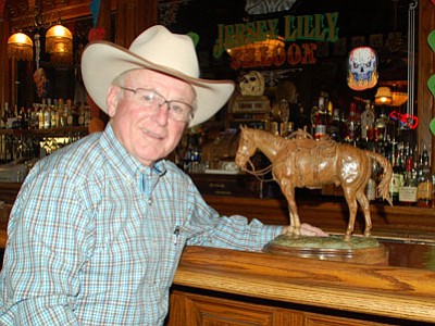 Jersey Lilly Saloon owner Tommy Meredith poses with Bill Nebeker’s bronze, the raffle prize for the Courthouse Lighting fundraiser. (Cindy Barks/The Daily Courier)