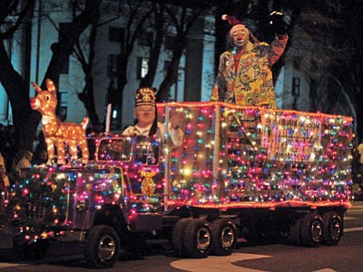 A festive Shriner clown waves to the crowd in the back of a small Christmas light covered semi-truck during the annual Holiday Light Parade in downtown Prescott in 2013. The parade is at 6 p.m. today. (Matt Hinshaw/The Daily Courier)