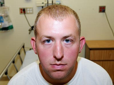 This undated file photo released by the St. Louis County Prosecuting Attorney's office Monday, Nov. 24, 2014, shows Ferguson police officer Darren Wilson during his medical examination after he fatally shot Michael Brown. Wilson has resigned from the Ferguson Police Department, nearly four months after the confrontation that fueled protests in the St. Louis suburb and across the U.S. (The Associated Press)