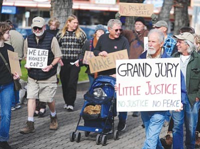 Les Stukenberg/The Daily Courier<br>
A group of 15 to 20 walk to protest against the Ferguson hearing and police brutality Friday on the courthouse plaza in downtown Prescott.