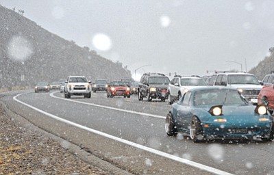 Daily Courier/Matt Hinshaw. Snow begins to fall Saturday afternoon while drivers traverse Highway 69 on their way into Prescott.