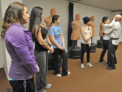 Matt Hinshaw/The Daily Courier<br>Geri Bryans demonstrates a self-defense technique on her instructor and husband, Mark Bryans, while from left, Lindsey Ward, Cori Gutirrez, Nancy Davis and Christen Buchheim look on at Champions Gym Wednesday afternoon in Prescott.