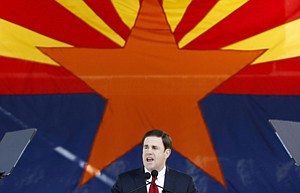 In this Jan. 5, 2015, file photo, Republican Arizona Gov. Doug Ducey addresses the crowd after being sworn in during inauguration ceremonies at the Arizona Capitol in Phoenix. The Arizona Legislature is putting a bill creating a new high school civics test on the fast track. Gov. Doug Ducey wants the bill to be the first to reach his desk, and the Senate and House education committees have set scheduled hearings for Thursday, Jan. 15, 2015. The bills require students to correctly answer 60 of 100 questions on the civics portion of the test required to become a U.S. citizen in order to graduate. Ducey said Monday that students just aren’t learning the basic civics they need to be good citizens. (AP Photo/Ross D. Franklin, File)