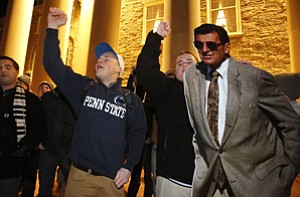 A group of Penn State students gather with a cardboard cutout of the late Penn State head football coach Joe Paterno outside Old Main on campus to celebrate the reversal of NCAA sanctions against the Penn State football program Friday, Jan. 16, 2015 in State College, Pa.. The NCAA has restored 112 of late head coach Joe Paterno's 409 career wins, reinstating Paterno as the winningest coach in major college football history. (AP Photo/Gene J. Puskar)