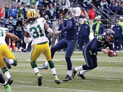 David J. Phillip/The Associated Press<br>
Seattle Seahawks’ Jon Ryan prepares to throw a touchdown pass on a fake field goal attempt during the second half of the NFC Championship game against the Green Bay Packers Sunday.