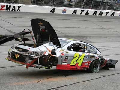 Dale Davis/The Associated Press<br>
Jeff Gordon’s car is towed to the garage after he was involved in an accident during the race at Atlanta Motor Speedway on Sunday.