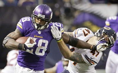 Ann Heisenfelt/The Associated Press<br>In this Dec. 1, 2013, file photo, Vikings running back Adrian Peterson, left, tries to break a tackle against the Bears in Minneapolis. A federal judge has cleared the way for Peterson to be reinstated. U.S. District Judge David Doty issued his order Feb. 26, less than three weeks after hearing oral arguments.