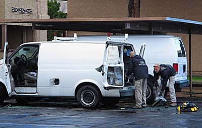 FBI investigators search a vehicle, Monday, May 4, 2015, in Phoenix, believed to belong to one of two gunmen who were shot and killed the night before outside a venue hosting an exhibit about the Prophet Muhammad in suburban Dallas. Garland, Texas, police officer Joe Harn says the men had opened fire with assault rifles, and that one officer had fatally shot both gunmen. (AP Photo/Brian Skoloff)