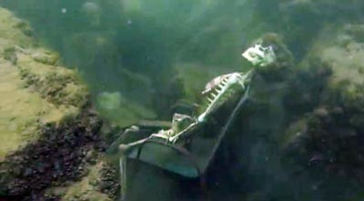 In this frame from video provided by the La Paz Sheriff's Office, fake skeletons are strategically placed to appear as if they were sitting together with their lawn chairs bound to large rocks in the Colorado River near the Arizona and California border. A man snorkeling came across the two fake skeletons sitting in lawn chairs about 40 feet underwater and reported the skeletons to the La Paz County Sheriff's Office on Monday, May 4, 2015, launching a hunt for what authorities believed could be real bodies. It turned out the skeletons were fake. (AP Photo/La Paz Sheriff's Office)