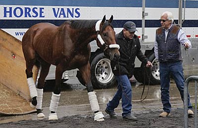Julie Jacobson/The Associated Press<br>Kentucky Derby and Preakness Stakes winner American Pharoah is led off a transport van by assistant trainer Jimmy Barnes as trainer Bob Baffert, right, gestures, Tuesday, June 2, at Belmont Park in Elmont, N.Y. American Pharoah will try for the Triple Crown on Saturday, June 6, in the 147th running of the Belmont Stakes horse race.