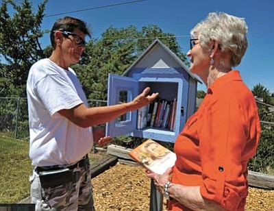 Matt Hinshaw/The Daily Courier<br>Handyman Dean Simmons talks with Yvonne Gerber about her families birthday surprise a Little Free Library book exchange named in her honor he built at the Peppertree Park in Prescott Thursday morning.