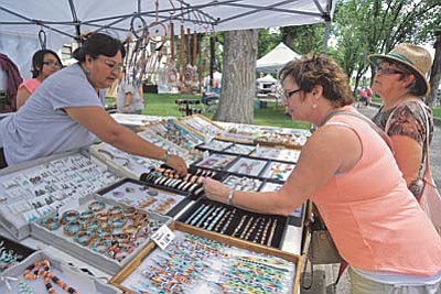 Matt Hinshaw/The Daily Courier<br>
Lita Thompson, left, of Kaibeto, Arizona shows P.Jai Smith a Navajo made copper bracelet while Patsy McCullough looks on during the Williamson Valley Fire District Arts & Crafts Show in downtown Prescott Saturday afternoon.