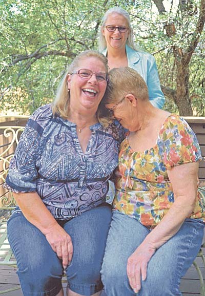 Matt Hinshaw/The Daily Courier<br /><br /><!-- 1upcrlf2 -->Lisa Rost, left, and her sister Celine Bruneau share a laugh while intermediary Margaret Dewey, behind them, looks on Tuesday afternoon at Celine's home in Prescott.  The sisters only recently found out about each other through Margaret Dewey.  Celine, the older sister, was adopted after birth while Lisa was raised by her birth mother.