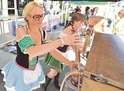 Matt Hinshaw/PNI<br /><br /><!-- 1upcrlf2 -->Kate Hope, left, and Katie Knapp pour a couple of beers for waiting patrons during the annual Prescott Oktoberfest last year in downtown Prescott.