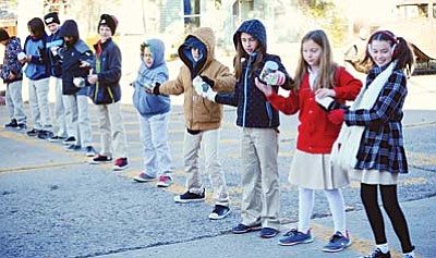 Les Stukenberg/
The Daily Courier<br>
Students from the Sacred Heart School in Prescott form a human chain to pass the food items from their school to the St. Vincent de Paul Food Bank Tuesday morning. 

