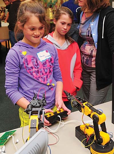 Les Stukenberg/The Daily Courier<br>Sarah and Riley Schlosberg get to try their hand running a robot as Embry-Riddle robotics faculty and students teamed up with the spot Museum and UniSource Energy Services to promote fun and learning through a series of robotics stations.