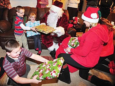 Les Stukenberg/The Daily Courier<br>Santa and his elves from the Firefighter Angel Foundation paid a visit to the Ross family in Prescott Valley. The foundation wrapped and delivered presents for 52 children from 17 families that the foundation has adopted this Christmas season.