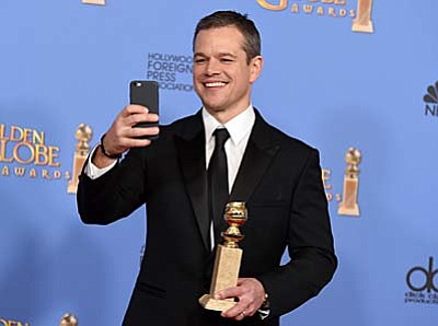 Matt Damon poses in the press room with the award for best performance by an actor in a motion picture - musical or comedy for “The Martian” at the 73rd annual Golden Globe Awards on Sunday, Jan. 10, 2016, at the Beverly Hilton Hotel in Beverly Hills, Calif. (Photo by Jordan Strauss/Invision/AP)