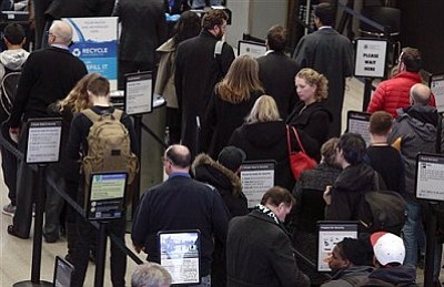 Travelers wait in a security line at O'Hare International Airport Friday, Jan. 22, 2016 in Chicago. Airlines at Chicago's two major airports have canceled 215 flights largely due to a blizzard threatening down on the East Coast. (AP Photo/Teresa Crawford)
