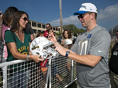 Marco Garcia/The AP<br>
New York Giants quarterback Eli Manning signs autographs before the NFL Pro Bowl football draft at Wheeler Army Airfield, Wednesday, Jan. 27, in Wahiawa, Hawaii.