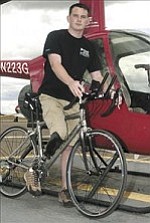 Courier/Nathaniel Kastelic
Ryan Kelly stands with his new Trek carbon-fiber Pilot 5.2 street bike Friday afternoon near the offices of Guidance Helicopters Inc. at the municipal airport in Prescott.