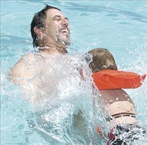 Courier/Nathaniel Kastelic
Four-year-old Jesse Rankin sends a splash toward his father, Jim, at the Chino Valley Aquatic Center Sunday afternoon. In celebration of Father¹s Day, all dads received free entry to the Public Open Swim.