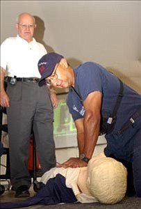 Courier/Jo. L. Keener
Dr. Gordon A. Ewy watches as Central Yavapai Fire District Capt. Armando Valadez performs the ³new CPR² on a dummy. The new-style CPR, which Ewy advocates, calls for continuous compressions, but the overall medical community has not adopted it. Case studies show the new method keeps blood circulating in the body until paramedics arrive.