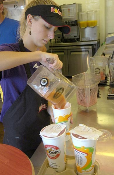 The Daily Courier/Jo.L. Keener 
Sam Bashore pours finished smoothies into cups Friday at Robeks in Prescott.
