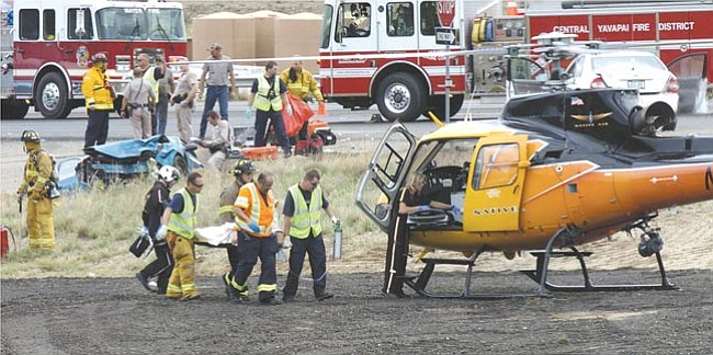 Rescue workers transport an injured person to a waiting helicopter for airlift to a Phoenix hospital. A two-vehicle accident Sunday afternoon on Highway 69 sent four people to hospitals.
